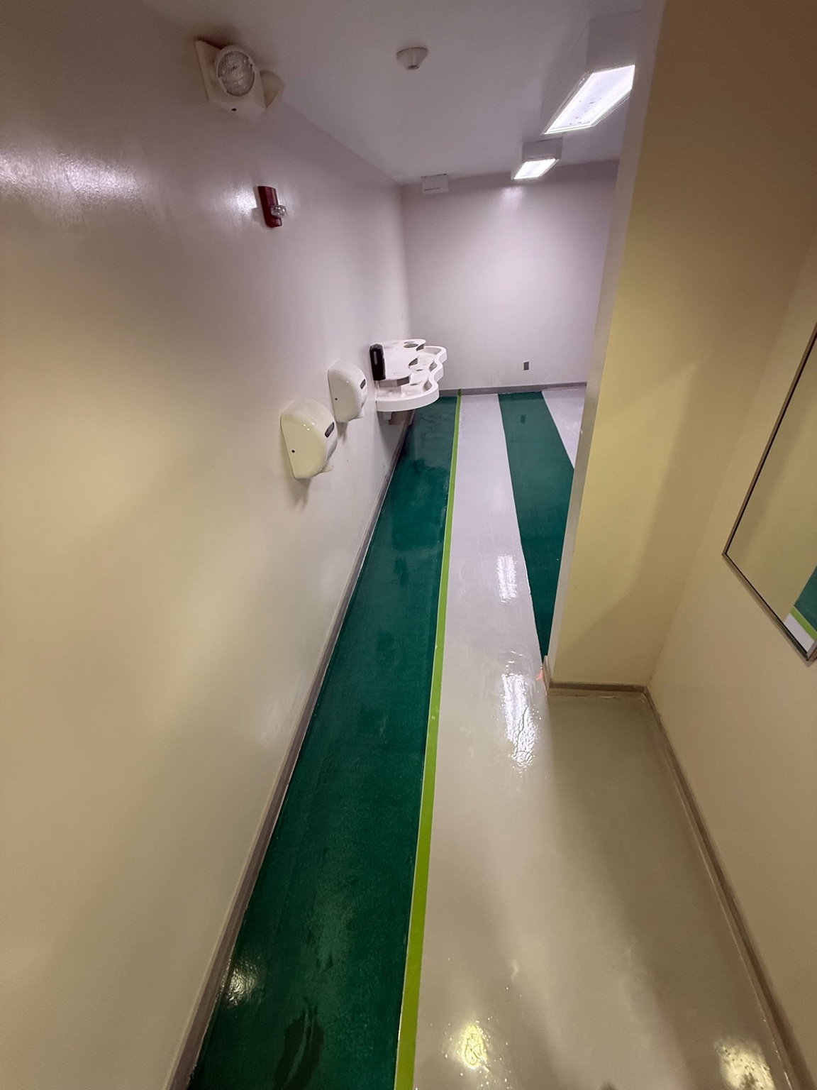 Green and white glossy epoxy floor in an Iowa commercial restroom