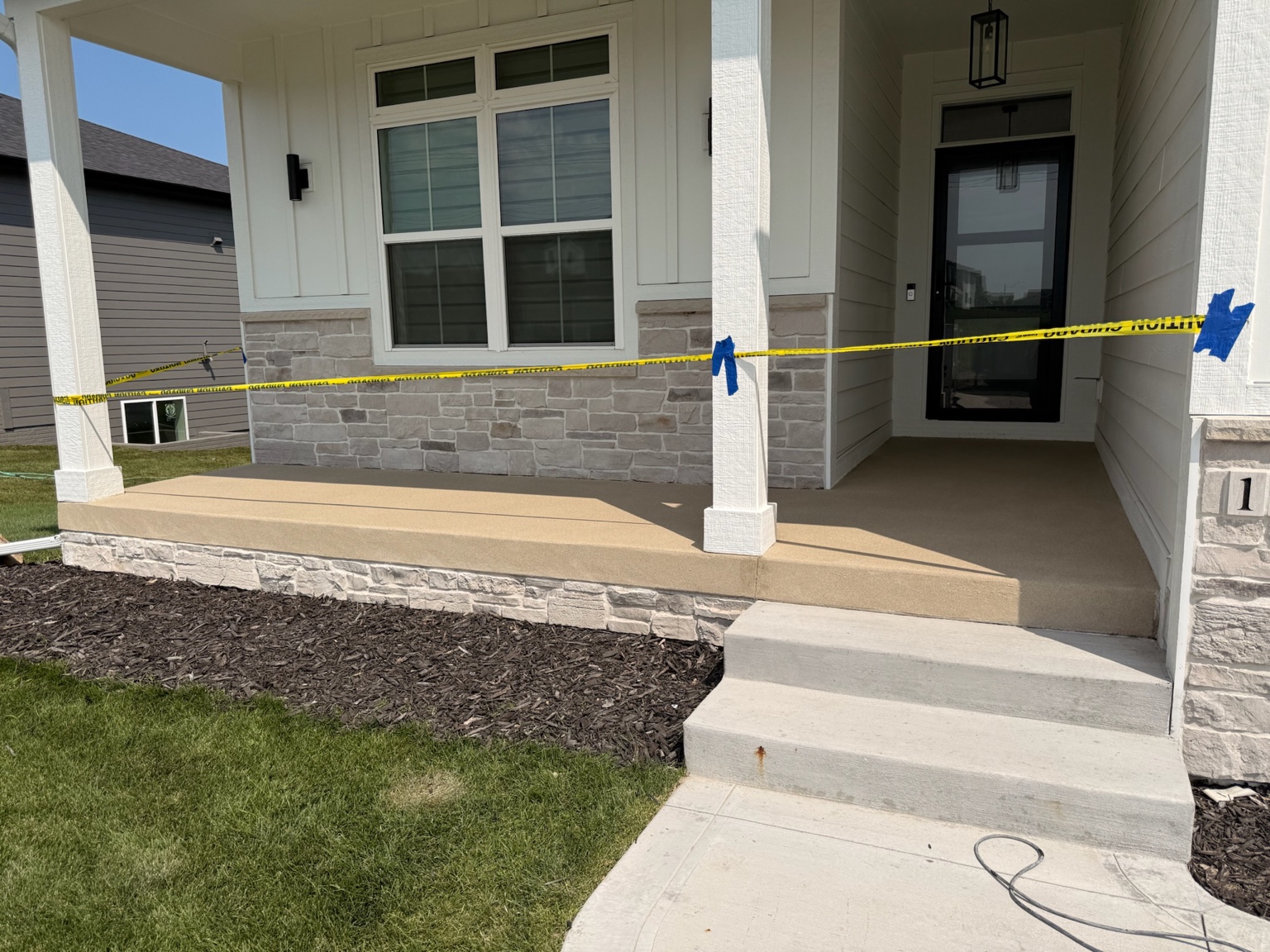 Finished tan concrete coating on the front porch of a Waterloo home