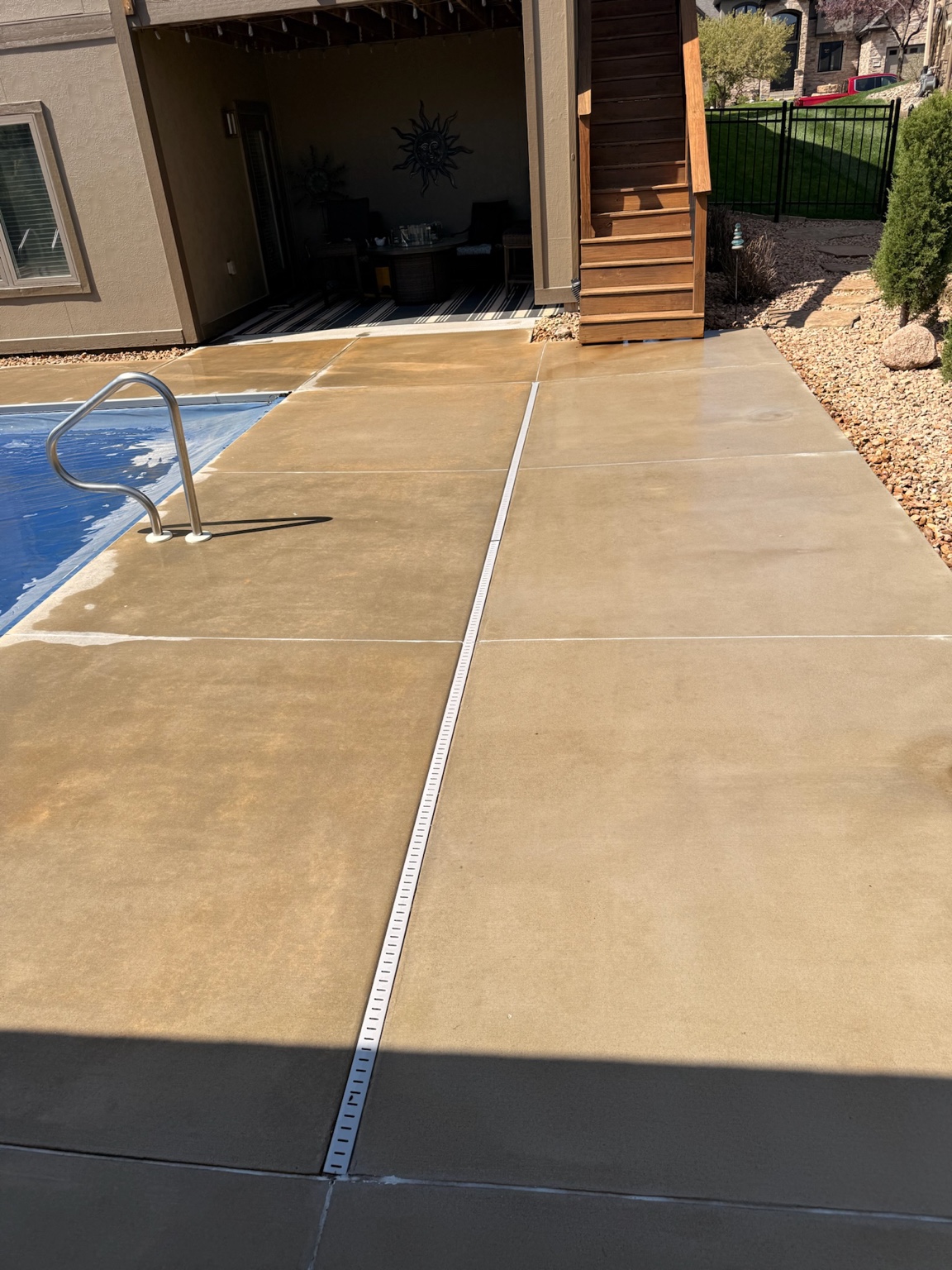 Restored tan concrete pool deck beside a Des Moines home