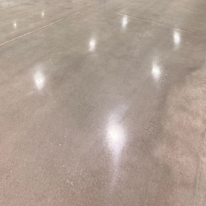 Polished concrete floor with a smooth matte sheen reflecting overhead lights
