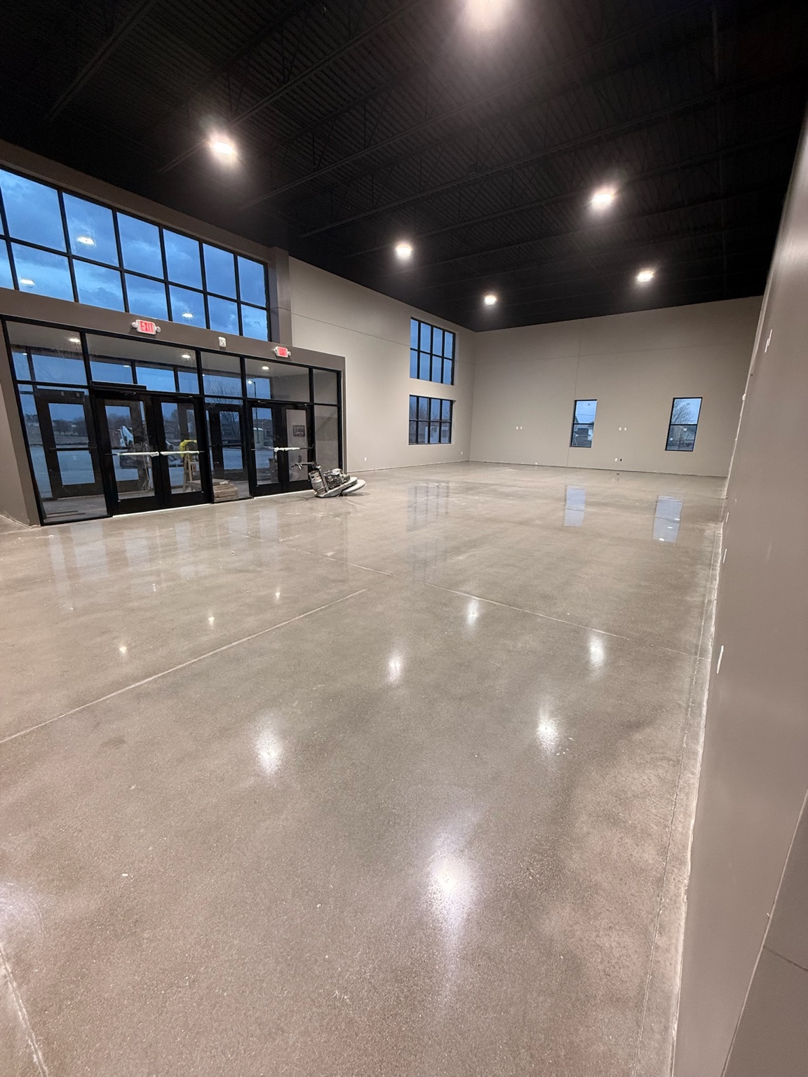 Large polished concrete floor reflecting ceiling lights in a Des Moines commercial showroom